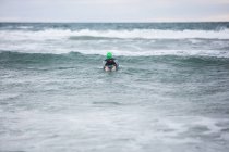 Спортсмен в гидрокостюме плавает в морской воде — стоковое фото