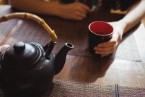 Seção intermediária de mulher tomando chá no restaurante — Fotografia de Stock