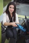 Beautiful woman charging electric car on street — Stock Photo