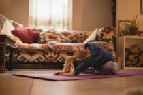 Menina realizando ioga na sala de estar em casa — Fotografia de Stock