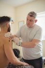 Physiotherapeut führt trockene Elektronadeln an der Schulter eines männlichen Patienten in der Klinik durch — Stockfoto