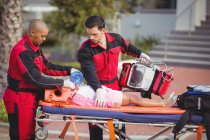 Paramédico dando oxigênio para menina ferida no local do acidente — Fotografia de Stock