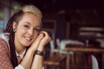 Портрет усміхненої жінки, що сидить у кафе — стокове фото