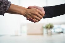 Dirigenti aziendali che si stringono la mano in ufficio — Foto stock