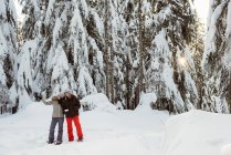 Paar mit Adresskarte zeigt auf eine Entfernung auf schneebedecktem Berg — Stockfoto