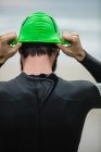 Rear view of athlete in wet suit wearing swim cap on the beach — Stock Photo