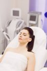 Female patient lying on dermatology chair in clinic — Stock Photo