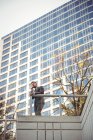 Homme d'affaires parlant sur un téléphone portable près d'un immeuble de bureaux — Photo de stock