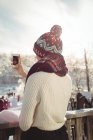 Visão traseira da mulher tirando uma foto usando telefone celular na estância de esqui — Fotografia de Stock