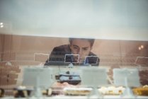 Бізнесмен дивиться на випічку в дисплеї — стокове фото