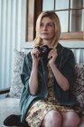 Задумчивая женщина с цифровой камерой — стоковое фото