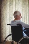 Senior man sitting on wheelchair in bedroom at home — Stock Photo