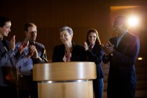 Colleagues applauding speaker after conference presentation at conference center — Stock Photo
