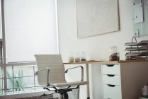 Silla y escritorio vacíos en la oficina - foto de stock