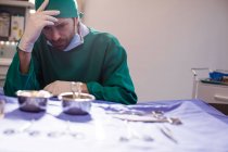 Cirujano tenso sentado en un quirófano en el hospital - foto de stock