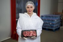 Портрет женщины-мясника, держащей мясной поднос на мясокомбинате — стоковое фото
