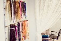 Assorted colourful artificial dreadlocks in shop — Stock Photo
