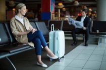 Thoughtful female commuter waiting in waiting area at airport — Stock Photo