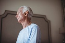 Thoughtful senior man in bedroom at home — Stock Photo