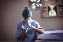 Enfermeira triste sentada em sala de operações no hospital — Fotografia de Stock