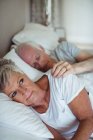 Senior couple lying on bed in bedroom — Stock Photo