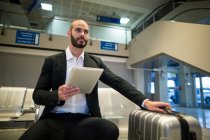 Бизнесмен с помощью цифрового планшета в аэропорту — стоковое фото
