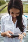 Junge Geschäftsfrau nutzt Handy auf Bürobalkon — Stockfoto
