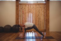 Mitte erwachsene Frau praktiziert Yoga im Fitnessstudio — Stockfoto