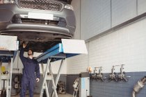 Механик осматривает машину в ремонтном гараже — стоковое фото