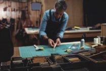 Craftswoman que trabalha em um pedaço de couro na oficina — Fotografia de Stock