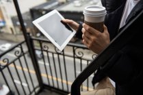 Mann benutzt digitales Tablet beim Kaffeetrinken auf Balkon — Stockfoto