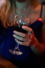 Close up of Woman holding glass of wine in the bar — Stock Photo