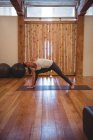 Жінка практикує трикутник йога позу в фітнес-студії — стокове фото