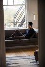 Чоловік говорить на мобільному телефоні у вітальні вдома — стокове фото
