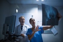 Médico e enfermeiro examinando raio-X no hospital — Fotografia de Stock