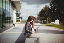 Беременная деловая женщина, использующая цифровой планшет в офисных помещениях — стоковое фото