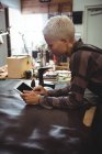 Зрелая ремесленница с помощью цифрового планшета в мастерской — стоковое фото