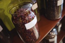 Close-up of spices jars arranged on shelves in shop — Stock Photo