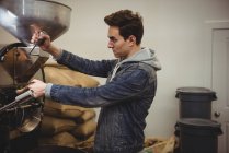 Человек с помощью кофе шлифовальный станок в кафе — стоковое фото