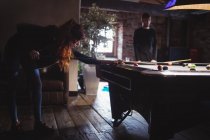 Young couple playing pool in bar — Stock Photo