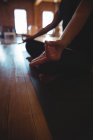 Vista ritagliata di meditare donna facendo mudra sul tappeto in studio di yoga — Foto stock