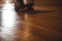 Close-up de piso de madeira no estúdio de fitness e praticando pessoa em segundo plano — Fotografia de Stock