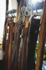 Различные кожаные аксессуары висят на крючках в мастерской — стоковое фото