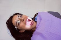 Paciente do sexo feminino recebendo tratamento com luz dentária na clínica odontológica — Fotografia de Stock