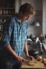 Homem de corte de tomates na placa de corte na cozinha — Fotografia de Stock