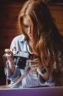 Красива жінка дивиться фотографії на цифрову камеру вдома — стокове фото
