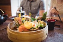 Close-up of various sushi in restaurant and couple in background — Stock Photo
