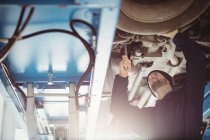 Mecânico de fixação de um carro na garagem de reparação — Fotografia de Stock