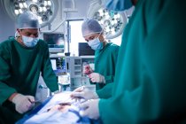 Chirurghi di sesso maschile e femminile che eseguono operazioni in sala operatoria di ospedale — Foto stock