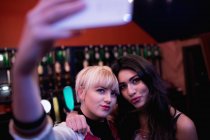 Amici che posano mentre scattano selfie sul cellulare nel bar — Foto stock